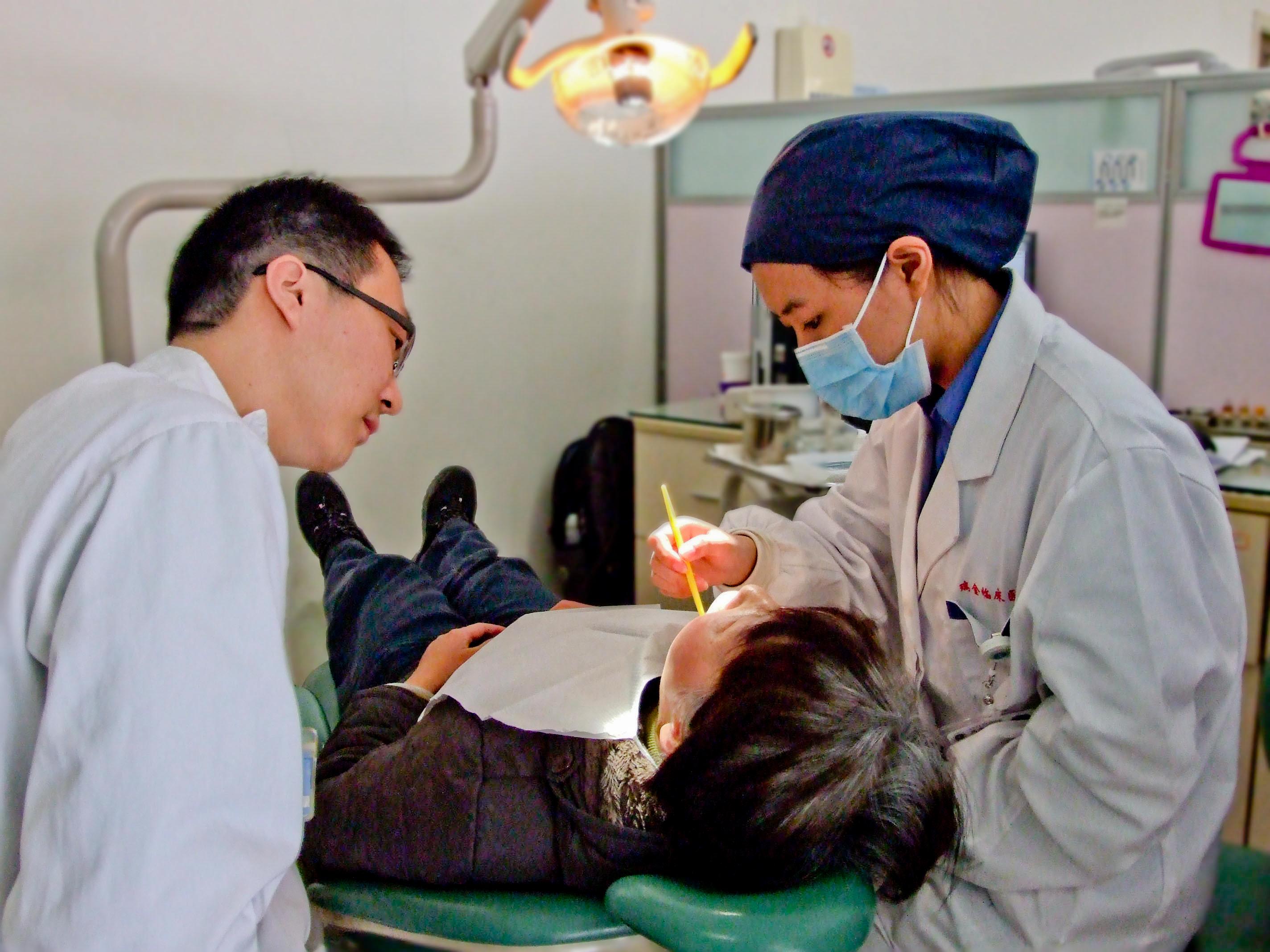 Projects Abroad Medical intern examines a young boys mouth in a dentist chair during a Medicine internship in China. Medical interns examine a young boys mouth at a Dental workshop during their Medicine placement in China.